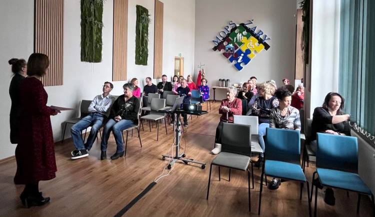 uczestnicy wideokonferencji siedzący na sali